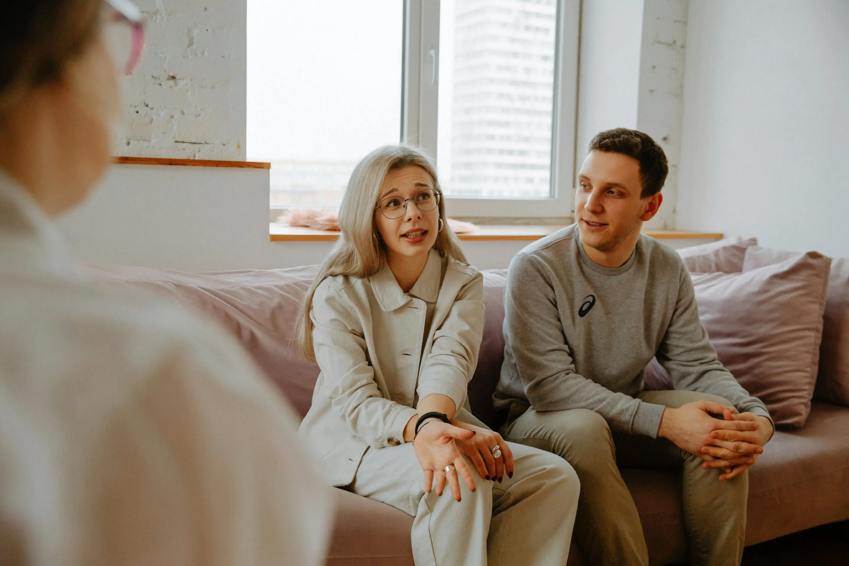 Trois jeunes discutant joyeusement dans un salon