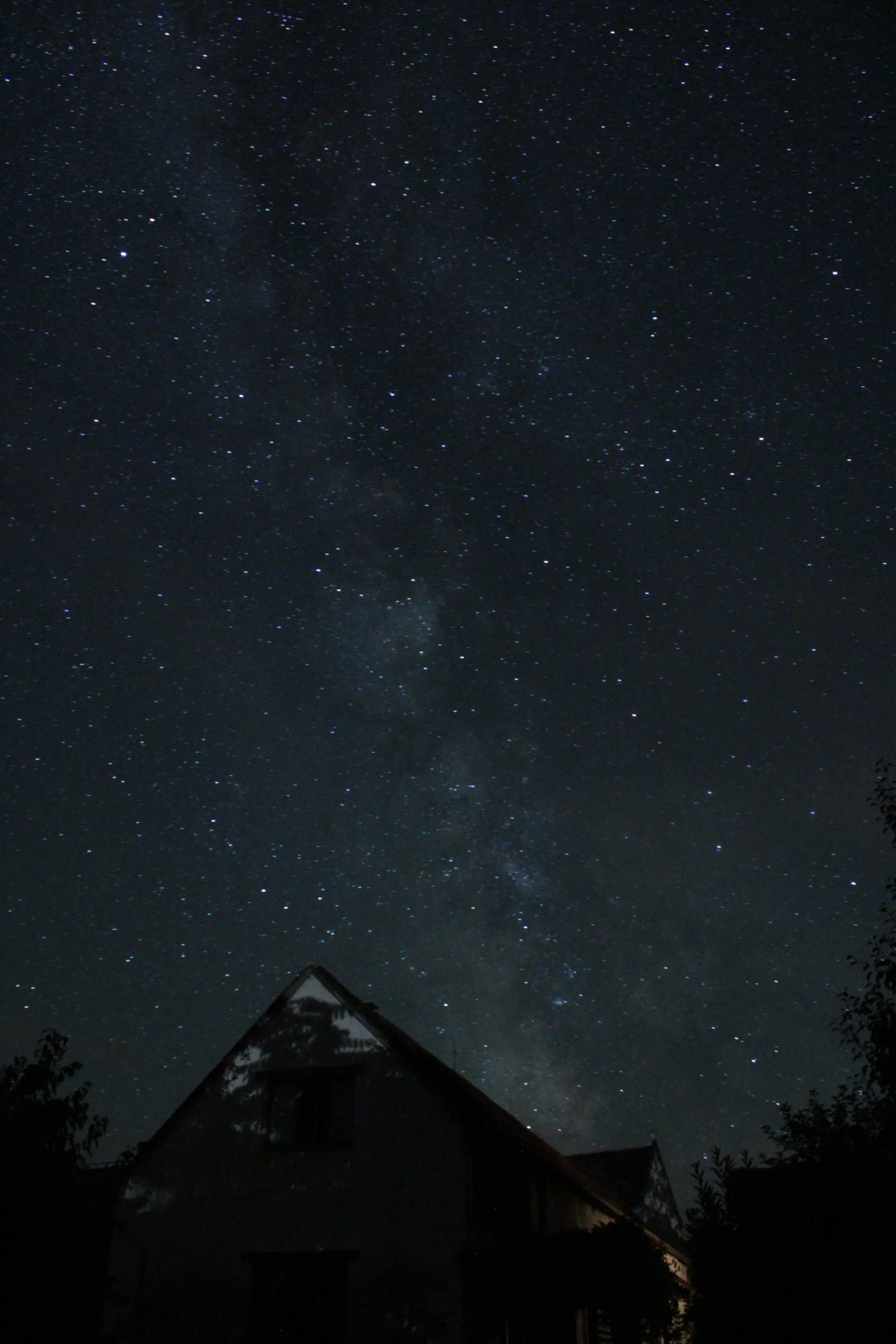 Maison nocturne sous ciel étoilé