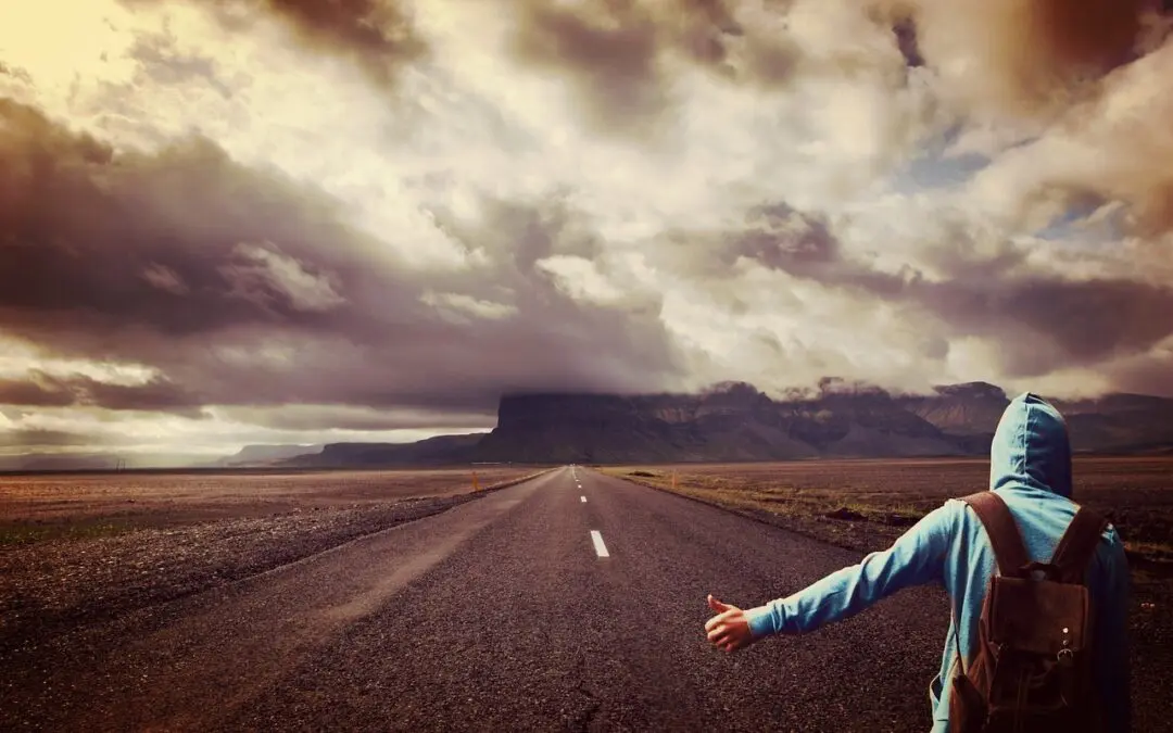 Personne auto-stoppeuse sur route montagneuse nuageuse