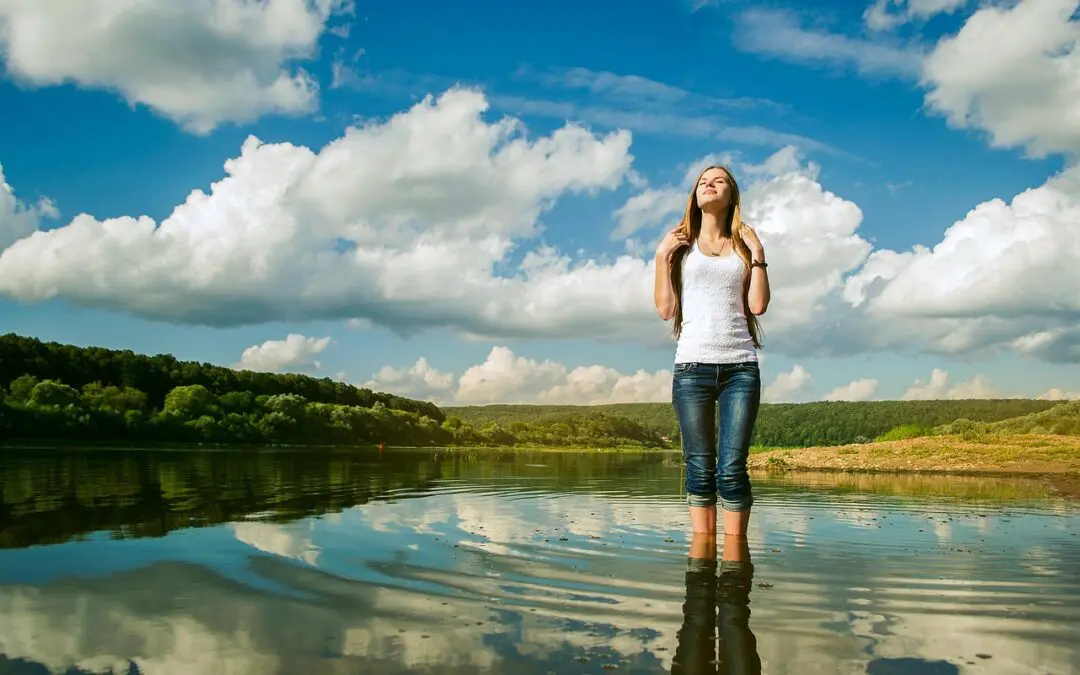 Femme debout dans l'eau, ciel nuageux