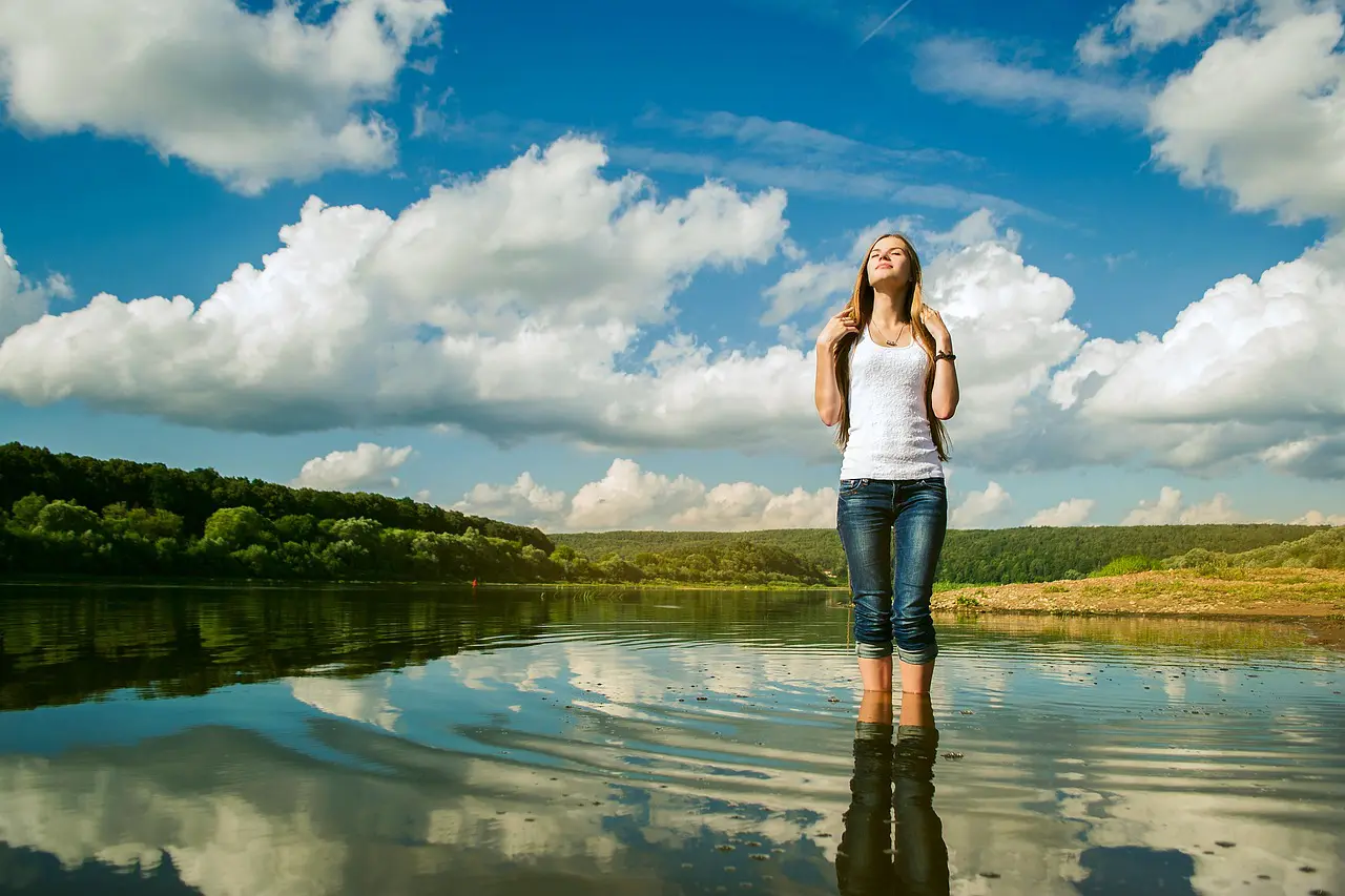 Femme debout dans l'eau, ciel nuageux