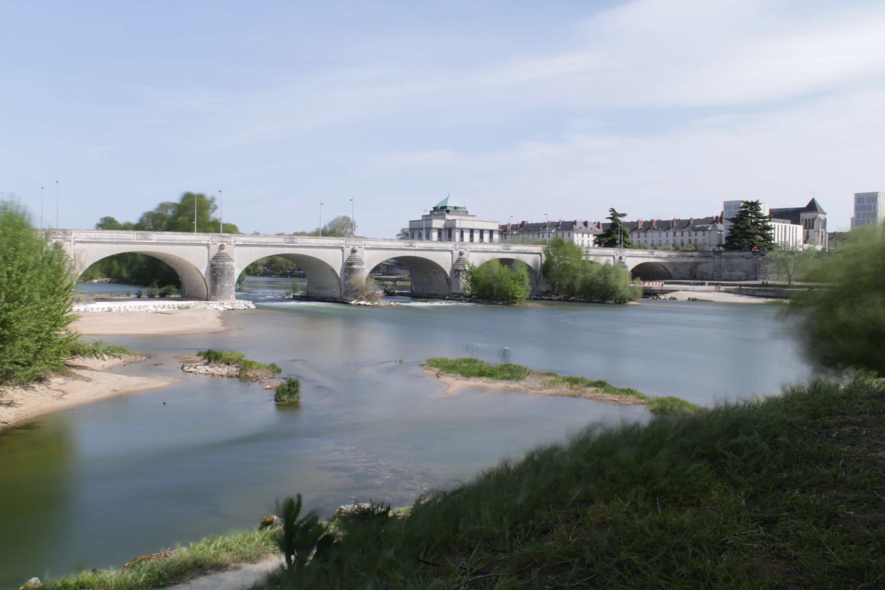 Pont ancien sur rivière calme, ville en arrière-plan